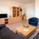 Aufenthaltszimmer im Hostel mit Sofa, Fernseher, Spieleschrank und einem Spiel auf dem Sofatisch