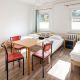 Dreibettzimmer im Hostel, in der Mitte ein Tisch, daneben ein Schrank