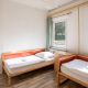 Zweibettzimmer im Hostel, rote Betten, weiße Bettwäsche und ein Waschbecken