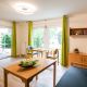 Wohnzimmer mit Holzmöbeln, Fernseher und kleinem Esstisch für 2 Personen