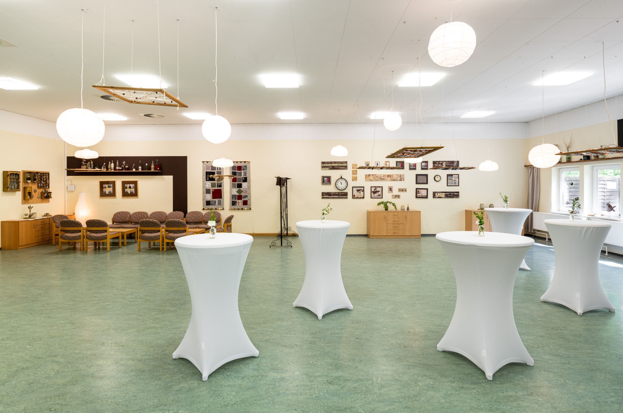 Stehtische in einem Tagungsraum, im Hintergrund eine Sitzgruppe